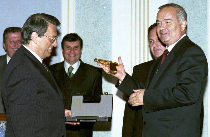 Ислам Каримов демонстрирует золотой пистолет, подаренный ему премьер-министром Турции Месутом Йылмазом. 13 апреля 1998 год. © Reuters